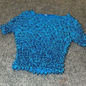 Shiny teal-colored popcorn tee 🦚